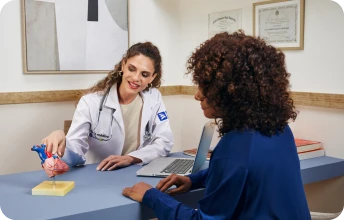 Profissional de saúde orientando paciente em consultório, representando atendimento qualificado no plano de saúde Porto Seguro PME